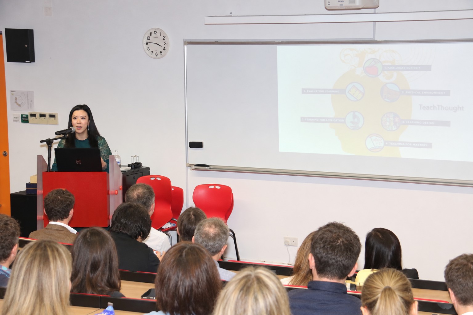 Dr Elsa delivering a talk about human potential at a podium